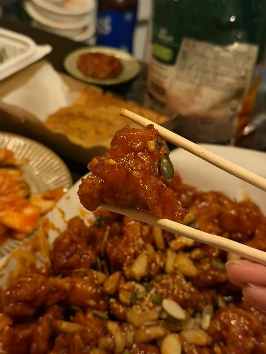 Close-up of garlic dakgangjeong with whole garlic cloves mixed in