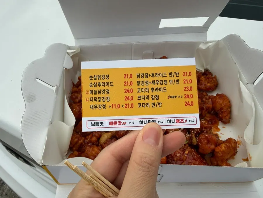 동명항 바다를 배경으로 든 닭강정 박스