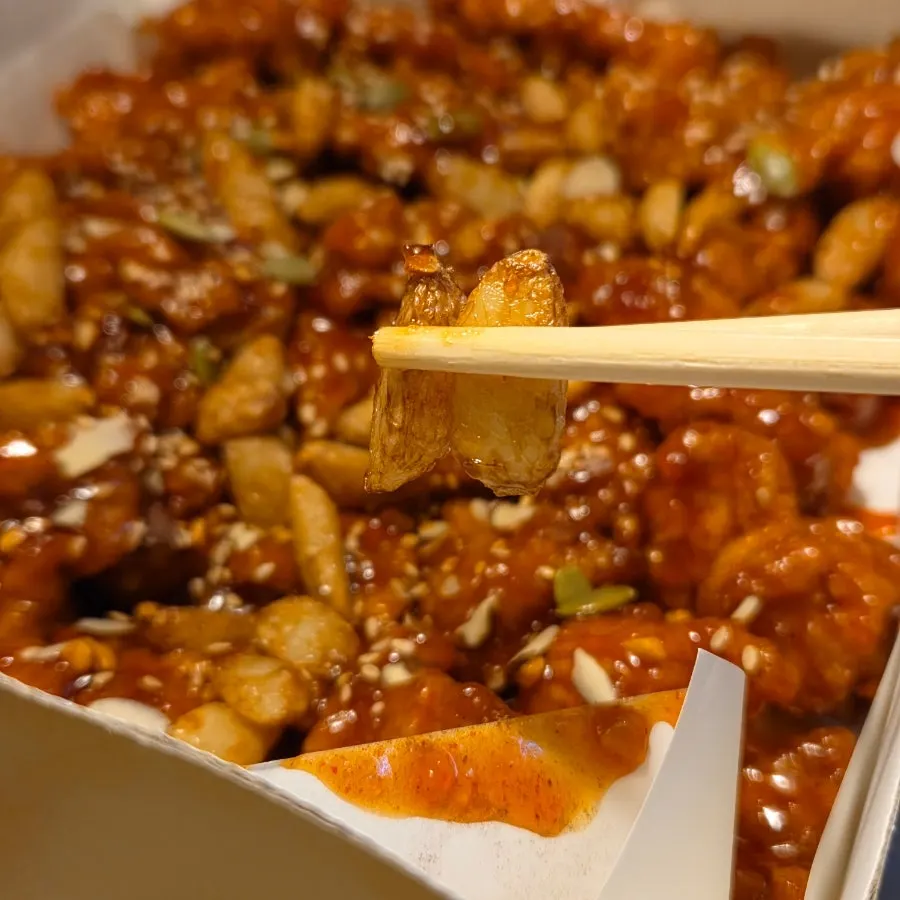 Boneless dakgangjeong topped with nuts and fried garlic
