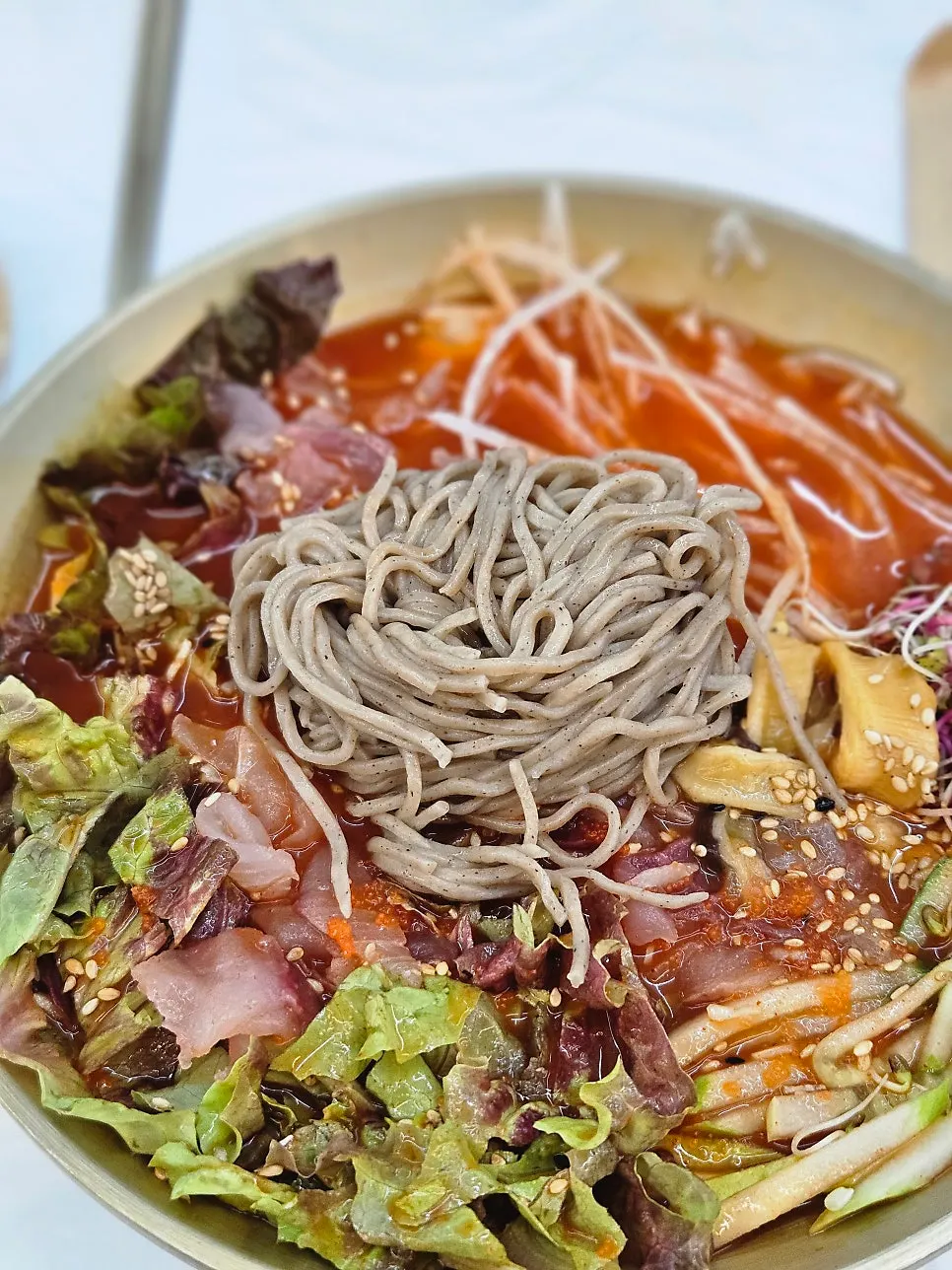 A chopstick-full of mulhoe with buckwheat noodles added