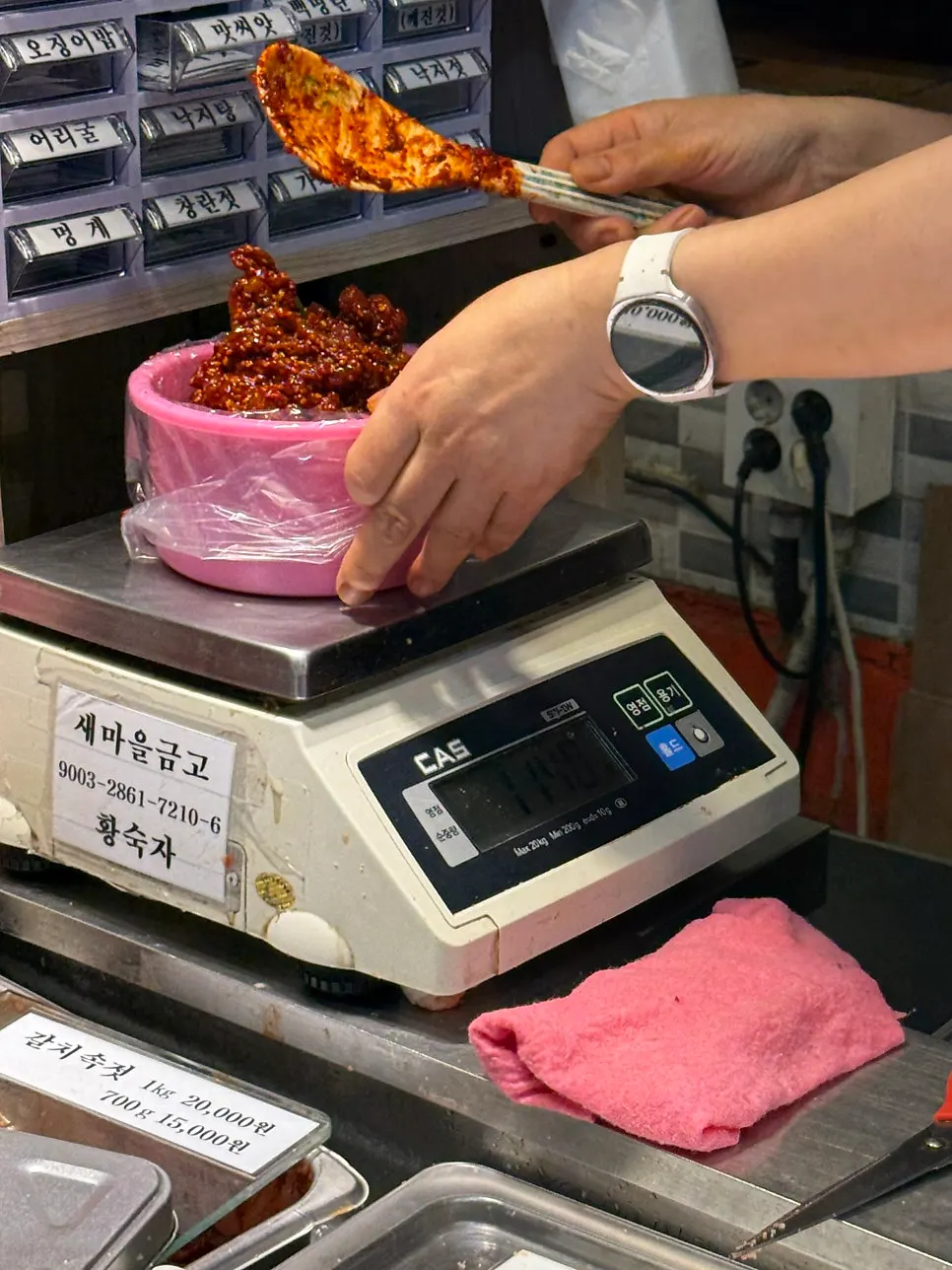 주문한 젓갈을 저울에 올려 무게 재는 모습