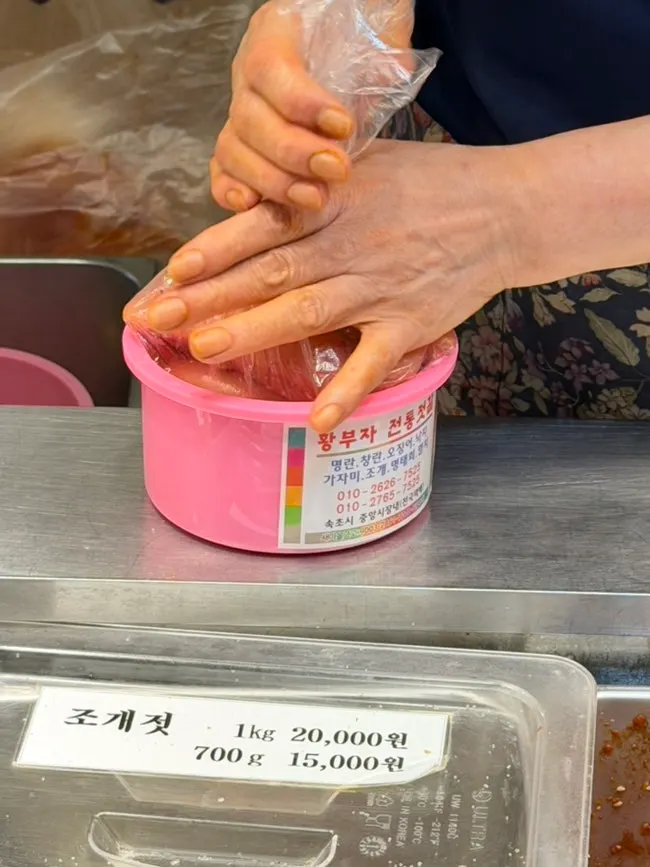 시장에서 구매한 젓갈 통을 든 모습