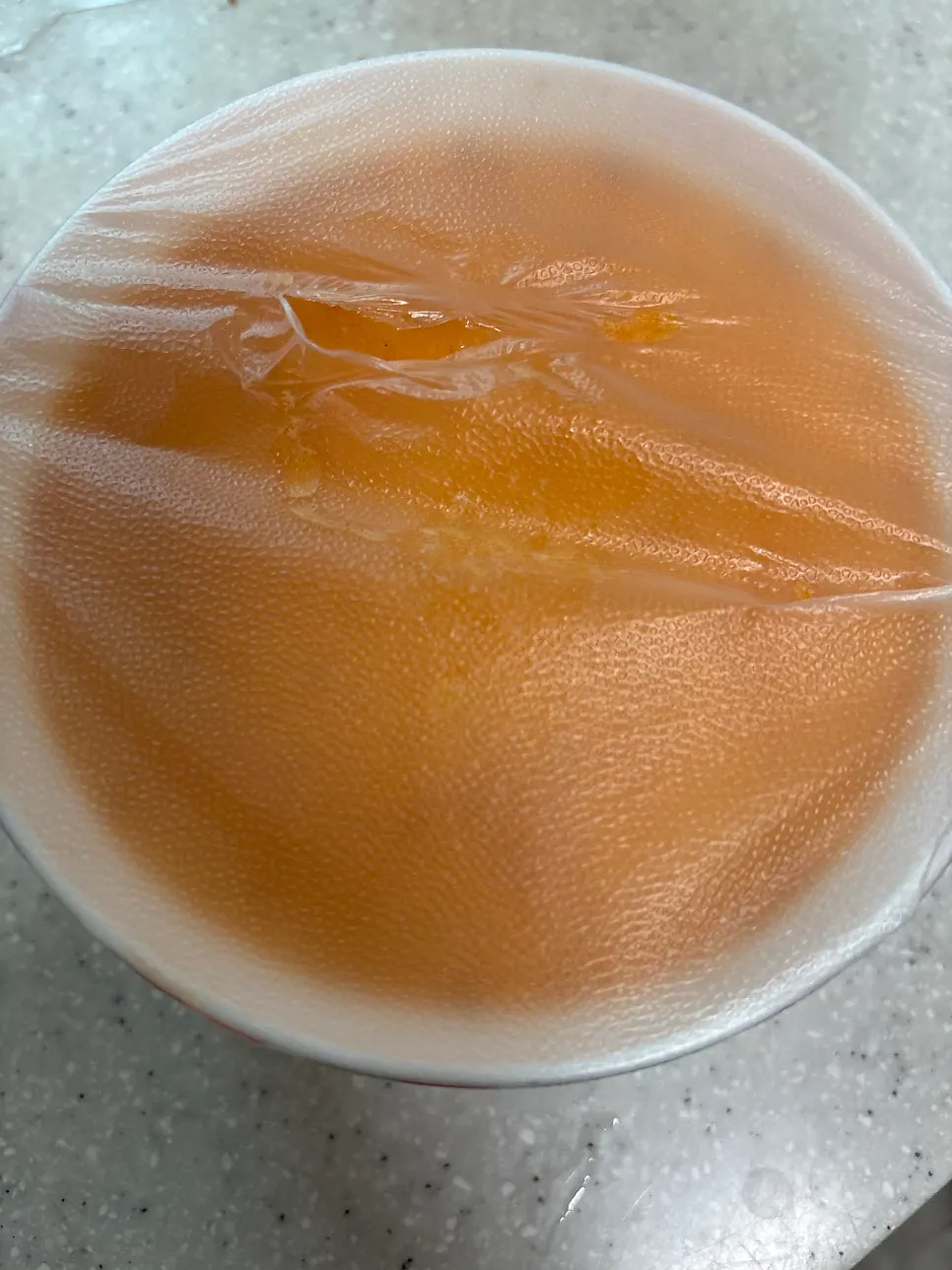 Microwave egg custard container covered with plastic wrap