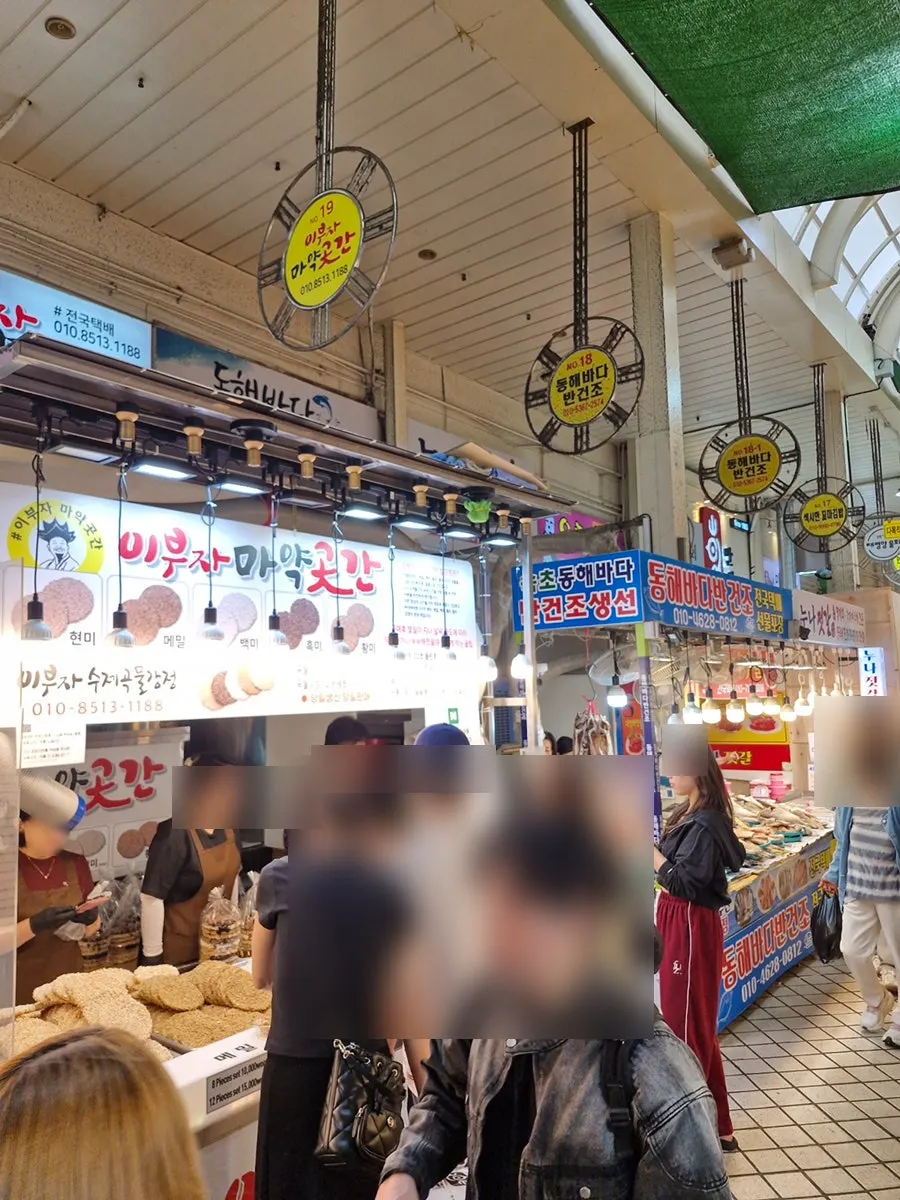 Busy Sokcho Central Market walkway crowded with Sunday afternoon visitors