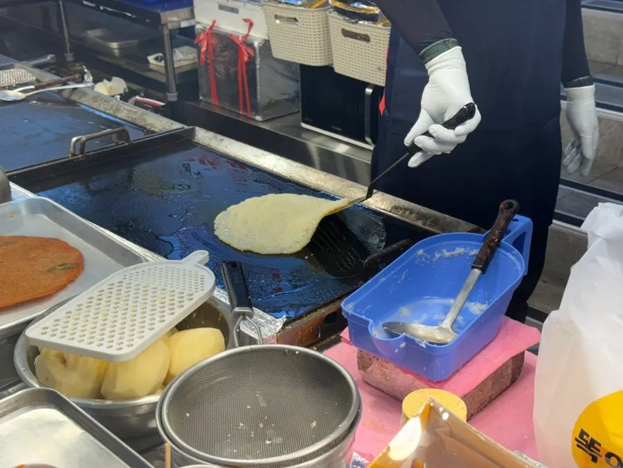 Potato pancake turning golden brown on the griddle