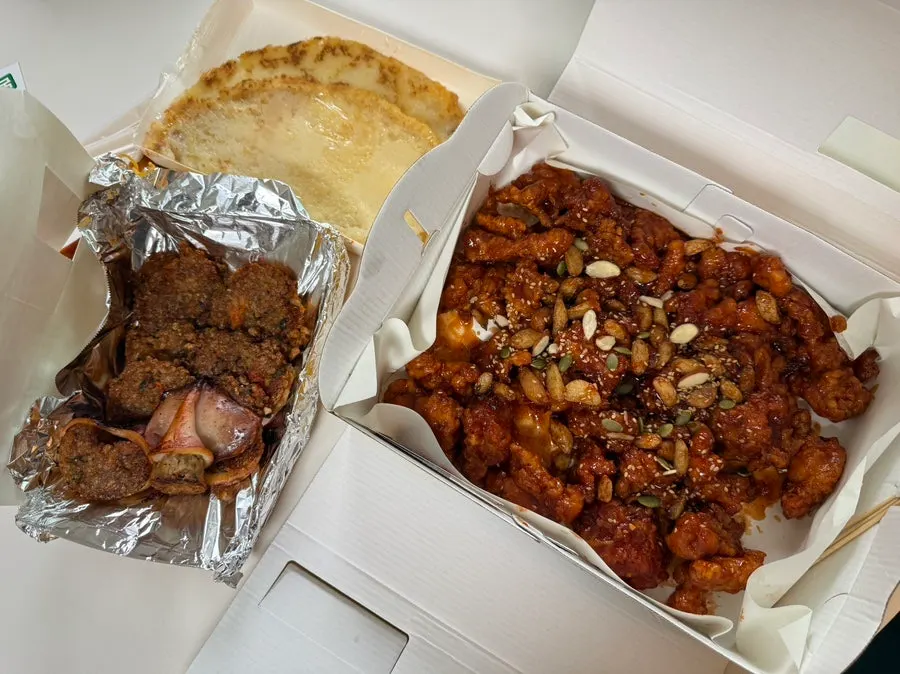 Fried chicken bites packed alongside squid sundae and potato pancake