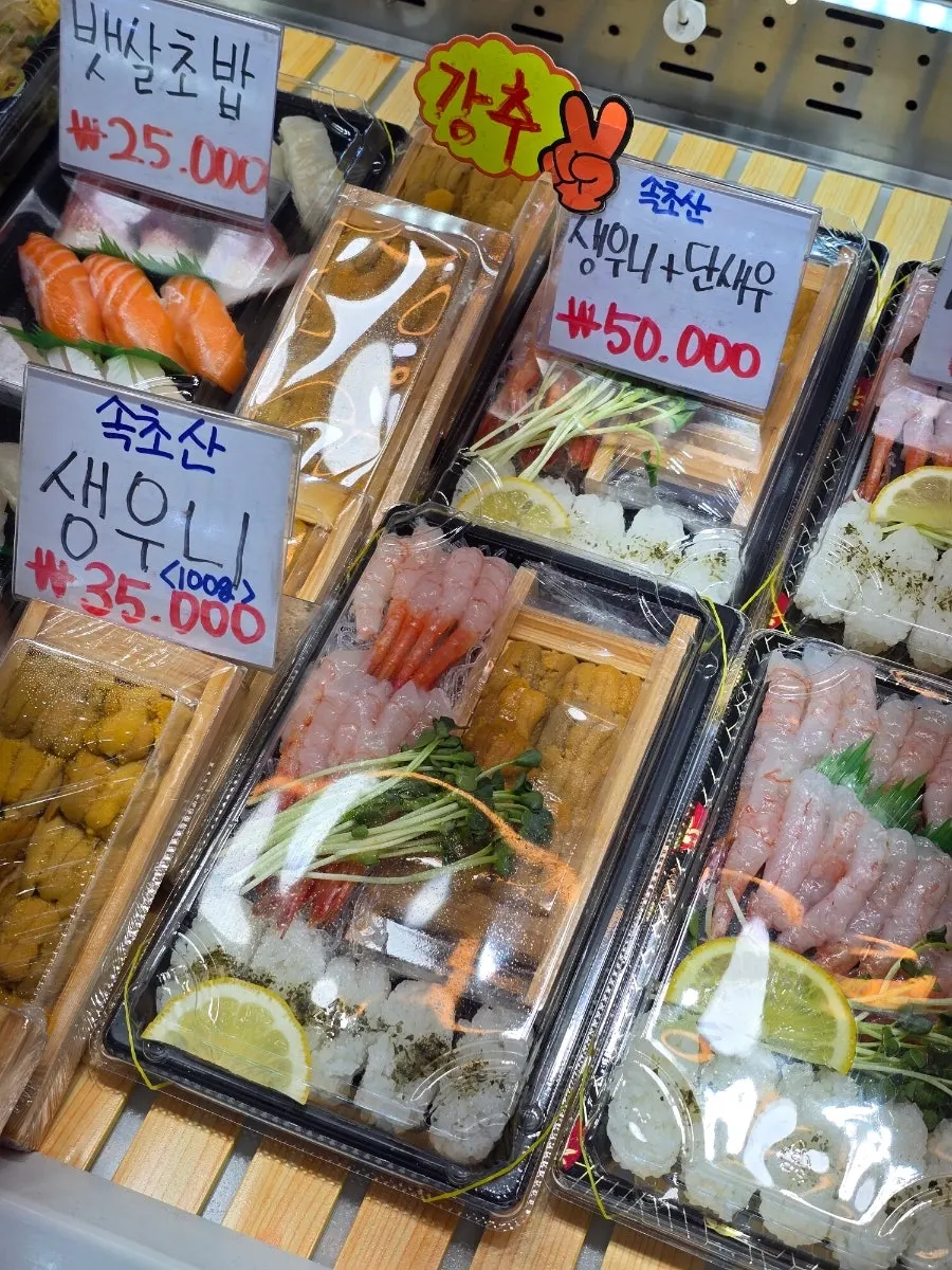 Sashimi takeout display case with price tags at Daeilho Bangeo