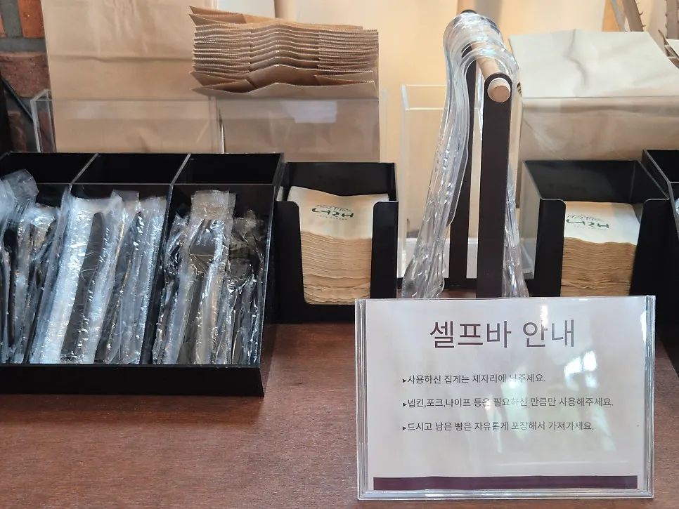 Self-service bar at Cafe Neorae with forks, knives and takeout containers