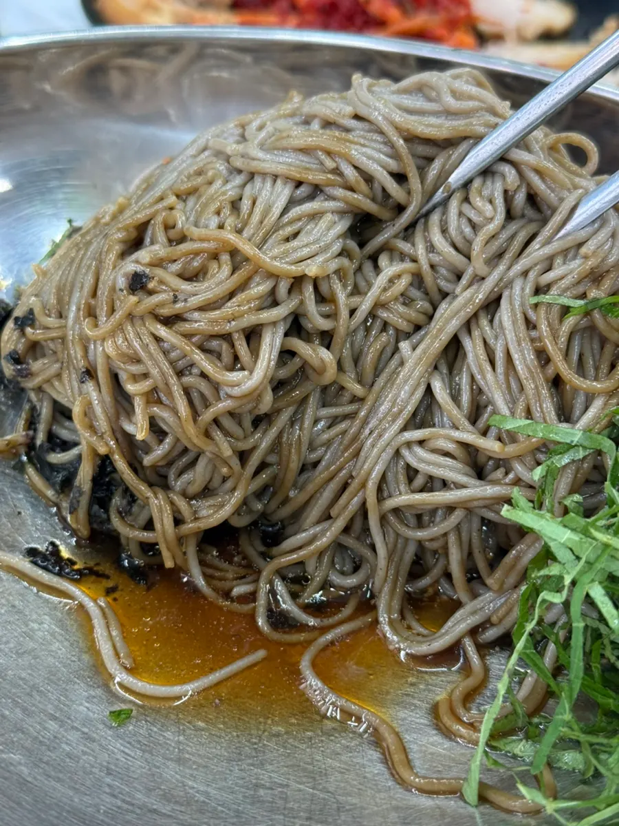 들기름 막국수를 비벼 젓가락으로 들어올린 모습
