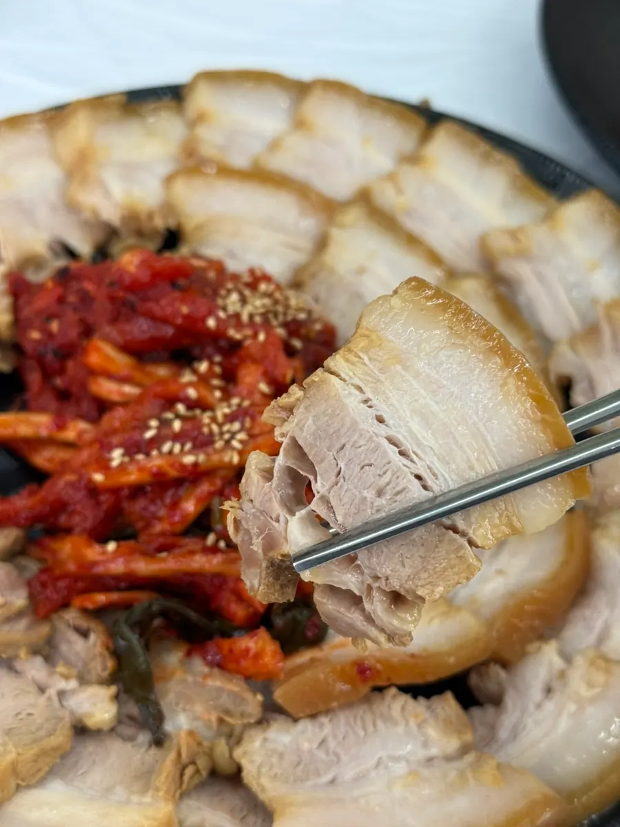수육 한 점에 무말랭이와 명태무침을 올린 모습