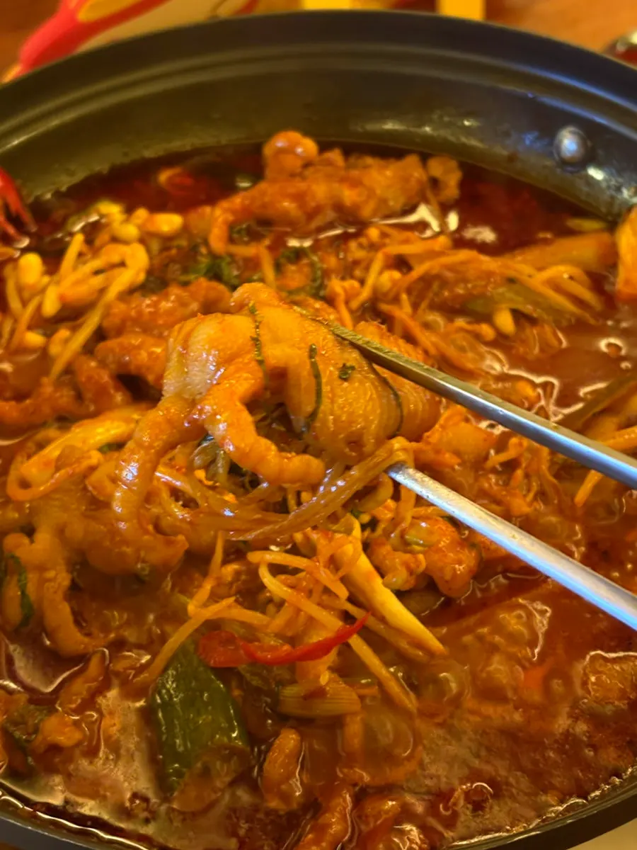 Spicy boneless chicken feet reduced down on a burner