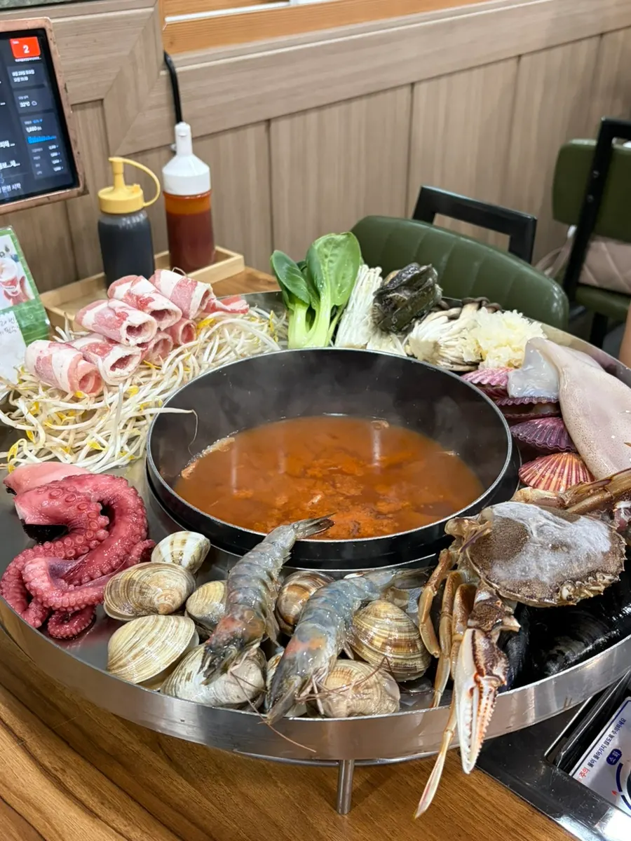 육수 냄비에 조개류를 넣는 모습