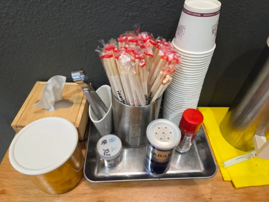 Table setting with water bottle and pepper and shichimi