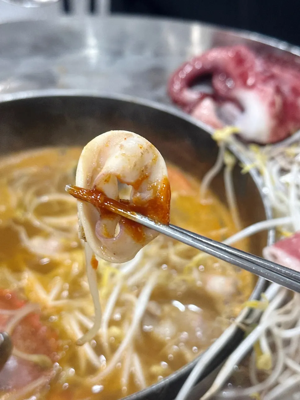 Seafood broth simmering on the tabletop burner
