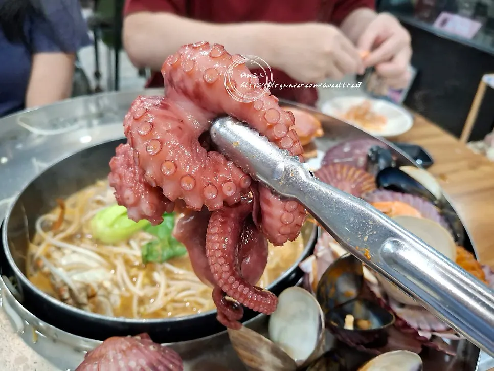 Plate of cooked seafood lifted out of the broth