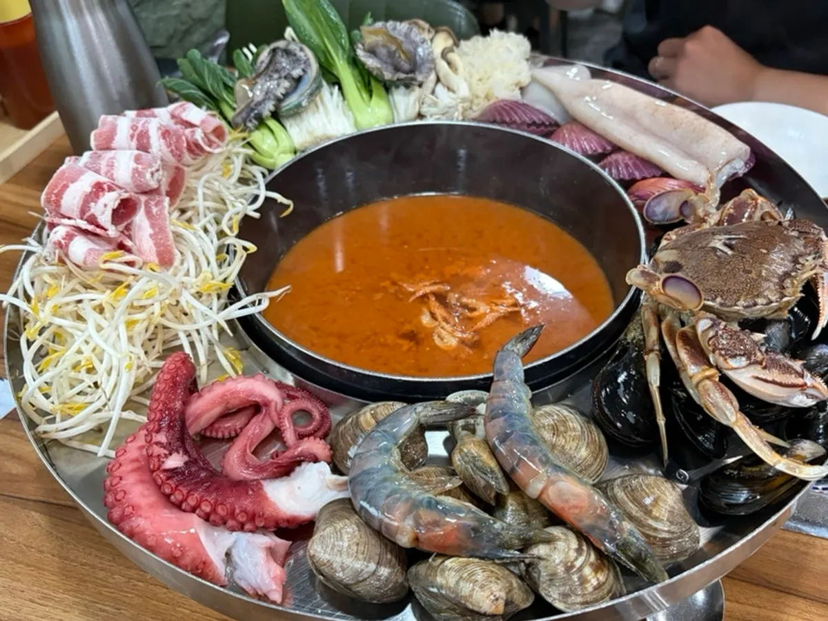 The red jangkalguksu shabu broth and full Haemul Kkot Jjaengban spread
