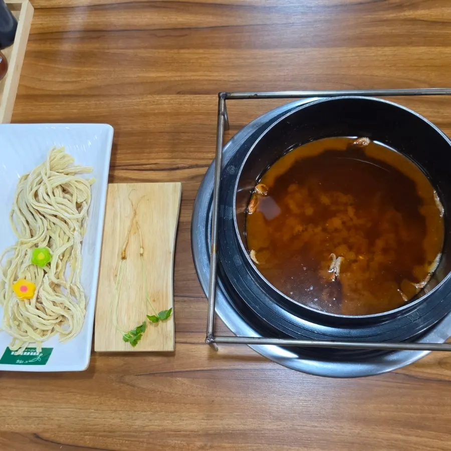 Kalguksu noodles topped with flower-shaped rice cakes
