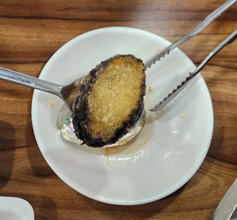 Cooked abalone separated with a spoon