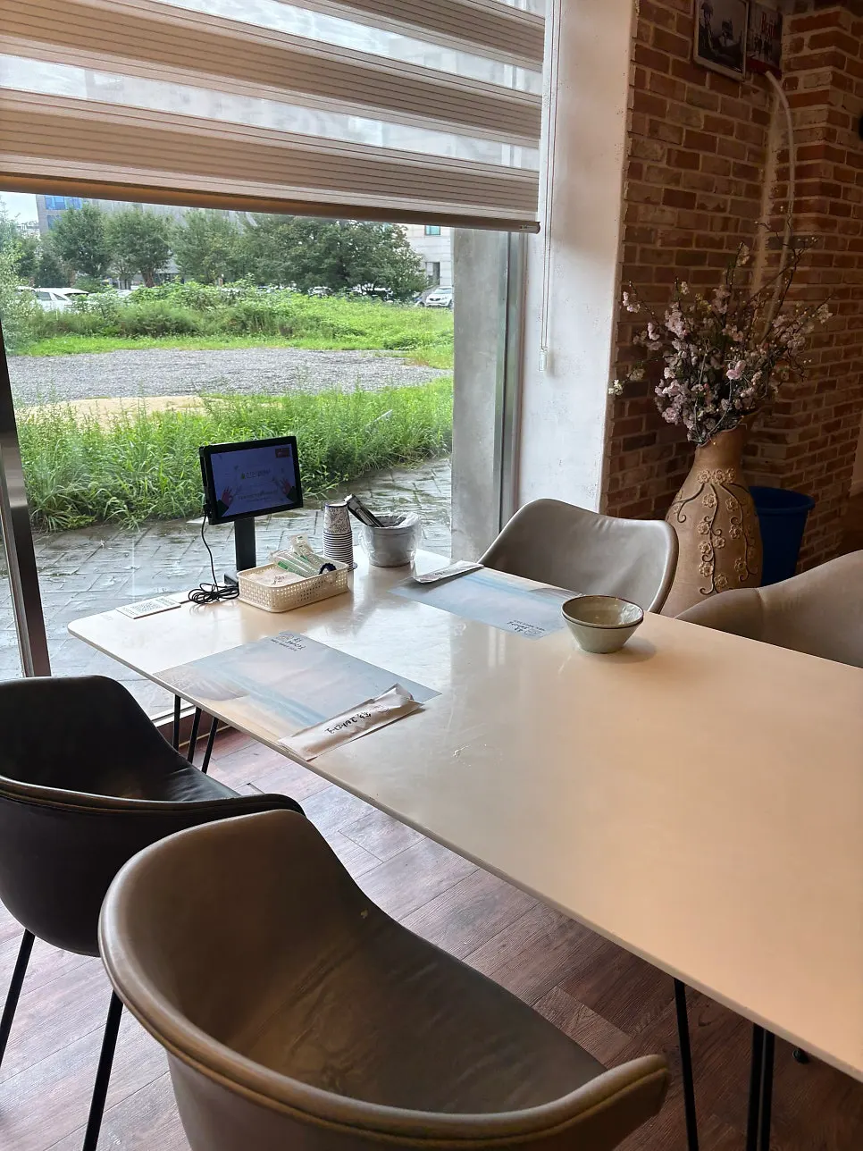 Table by the red brick wall with flower pots