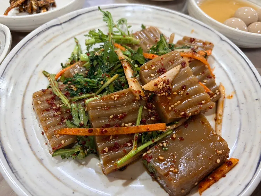 A side dish plate with japchae and jangjorim