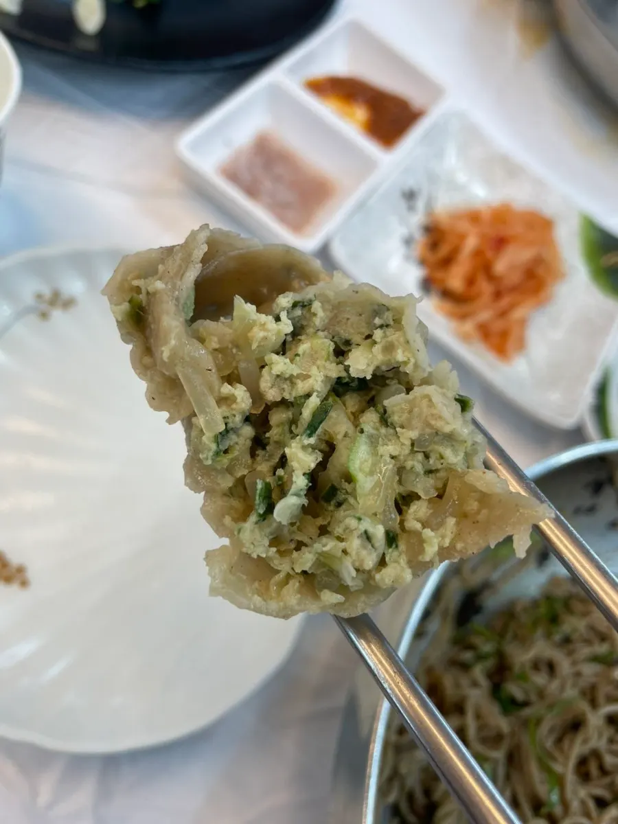 Buckwheat king mandu shown next to a hand for size comparison