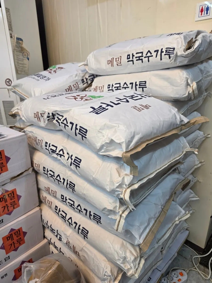 매장 벽면 사인과 쌓여 있는 메밀 막국수가루 포대