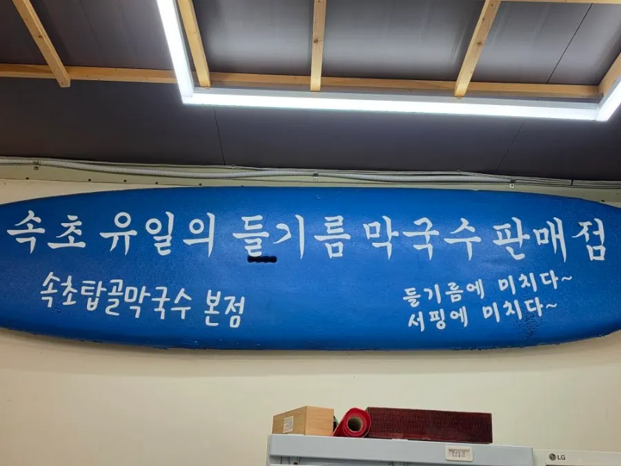음식을 천천히 내어 드리는 집이라고 적힌 식당 입구 현수막