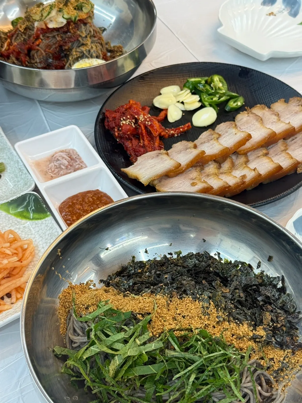 Table set with two bowls of makguksu and boiled pork