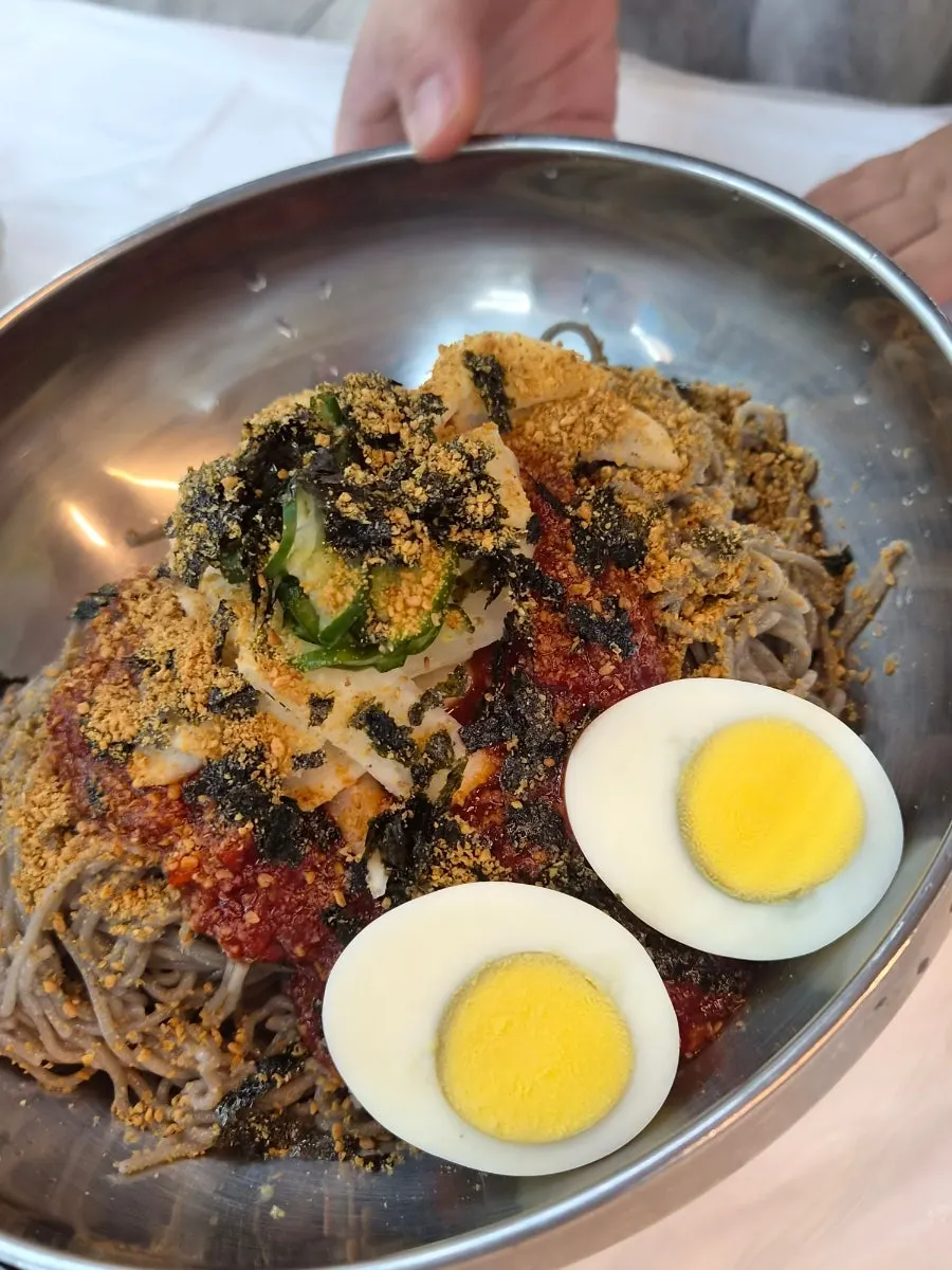 A bowl of perilla oil makguksu with its nutty aroma rising
