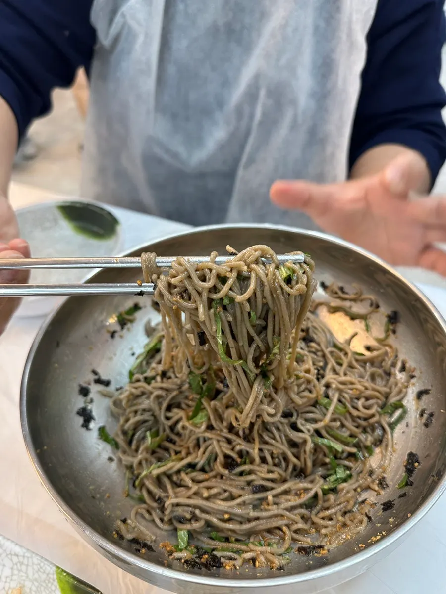 Perilla oil makguksu topped with perilla leaves and seaweed flakes