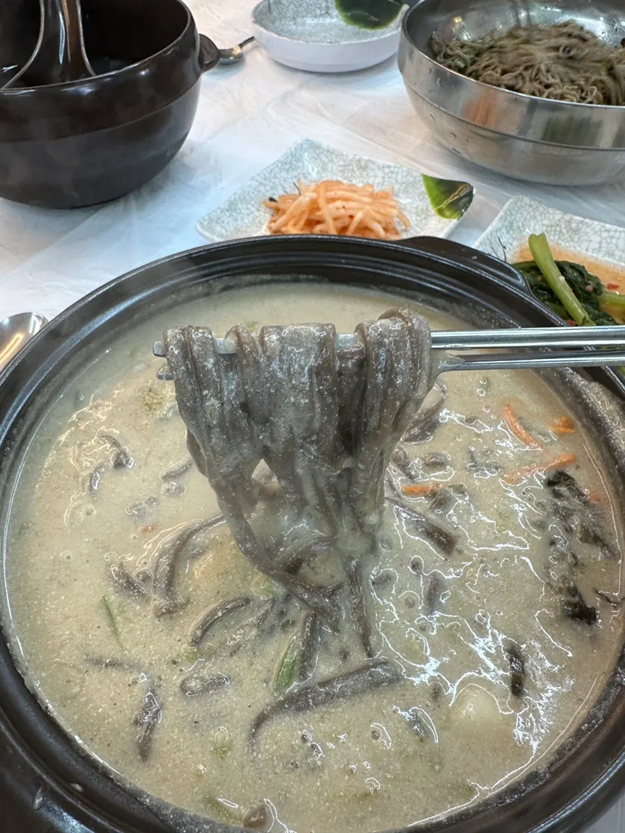 Buckwheat perilla kalguksu topped with carrot and perilla seeds