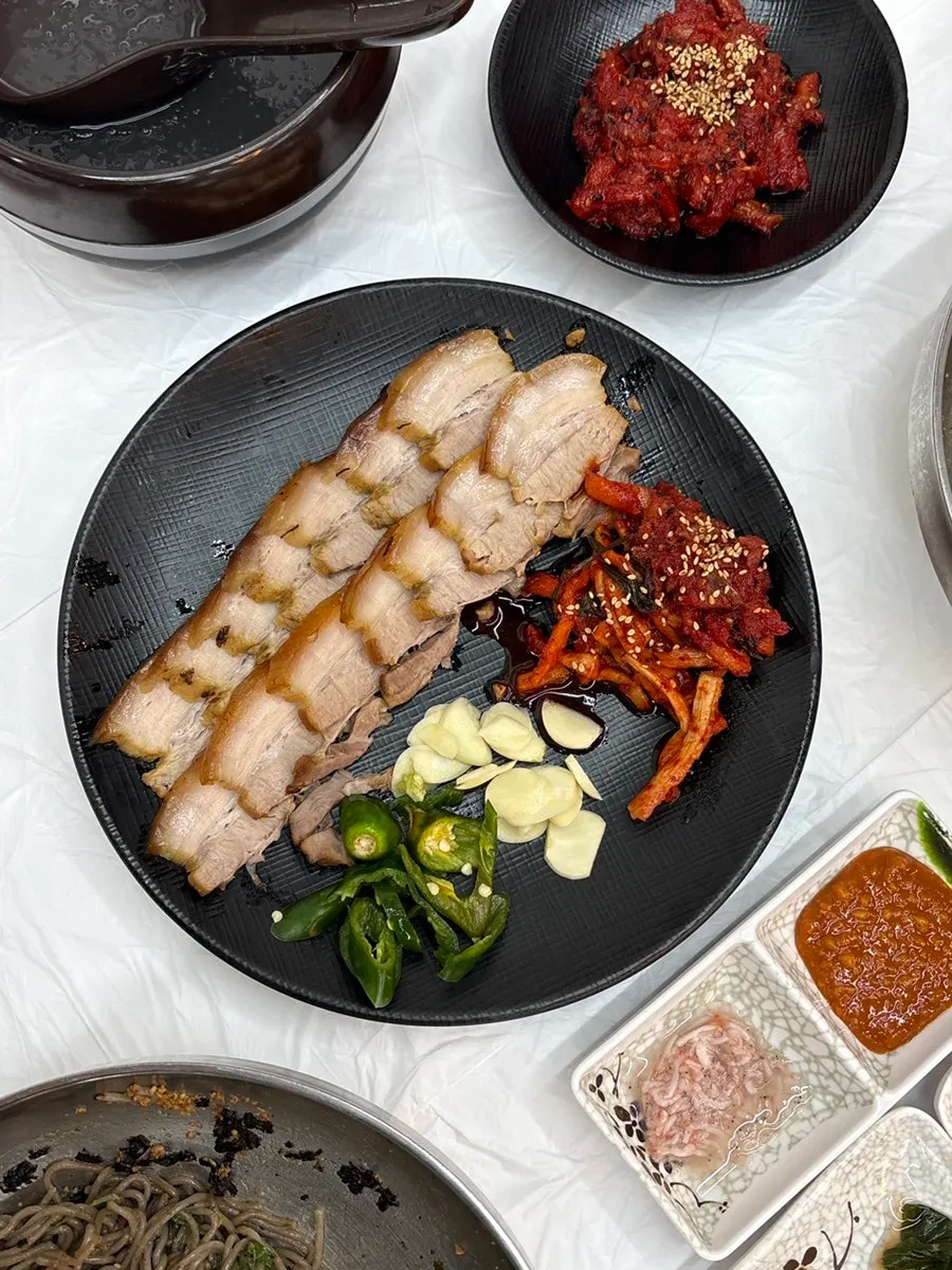 Single-serving suyuk topped with dried radish strips and pollack salad