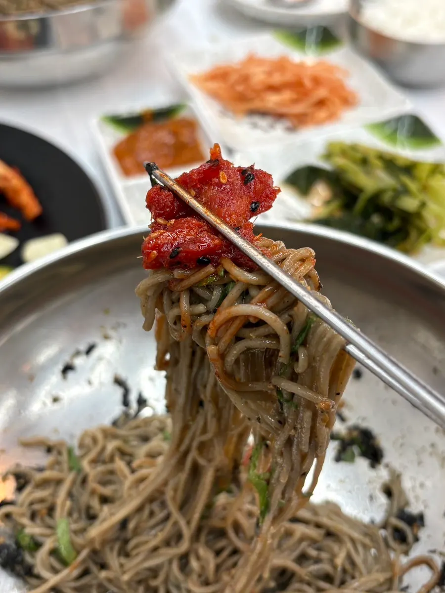 Chopsticks holding deulmemak and pollack salad together