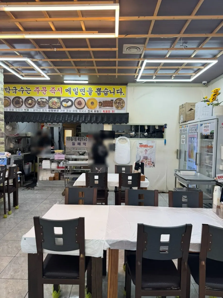 Kitchen with a sign noting buckwheat noodles are pressed fresh upon order