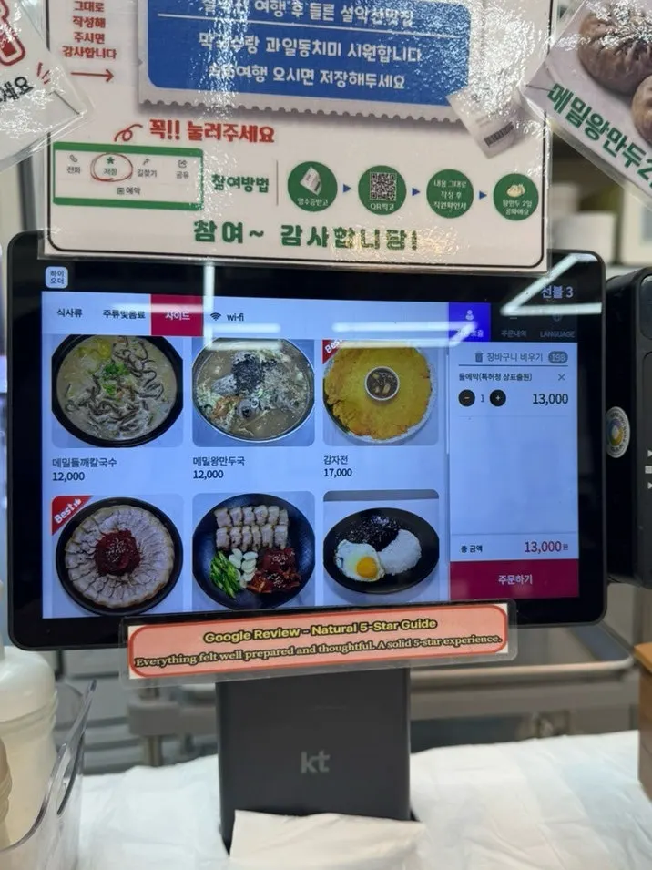 Menu board listing makguksu and side dish prices