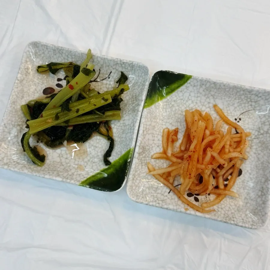 Side dishes of young radish greens and shredded radish salad