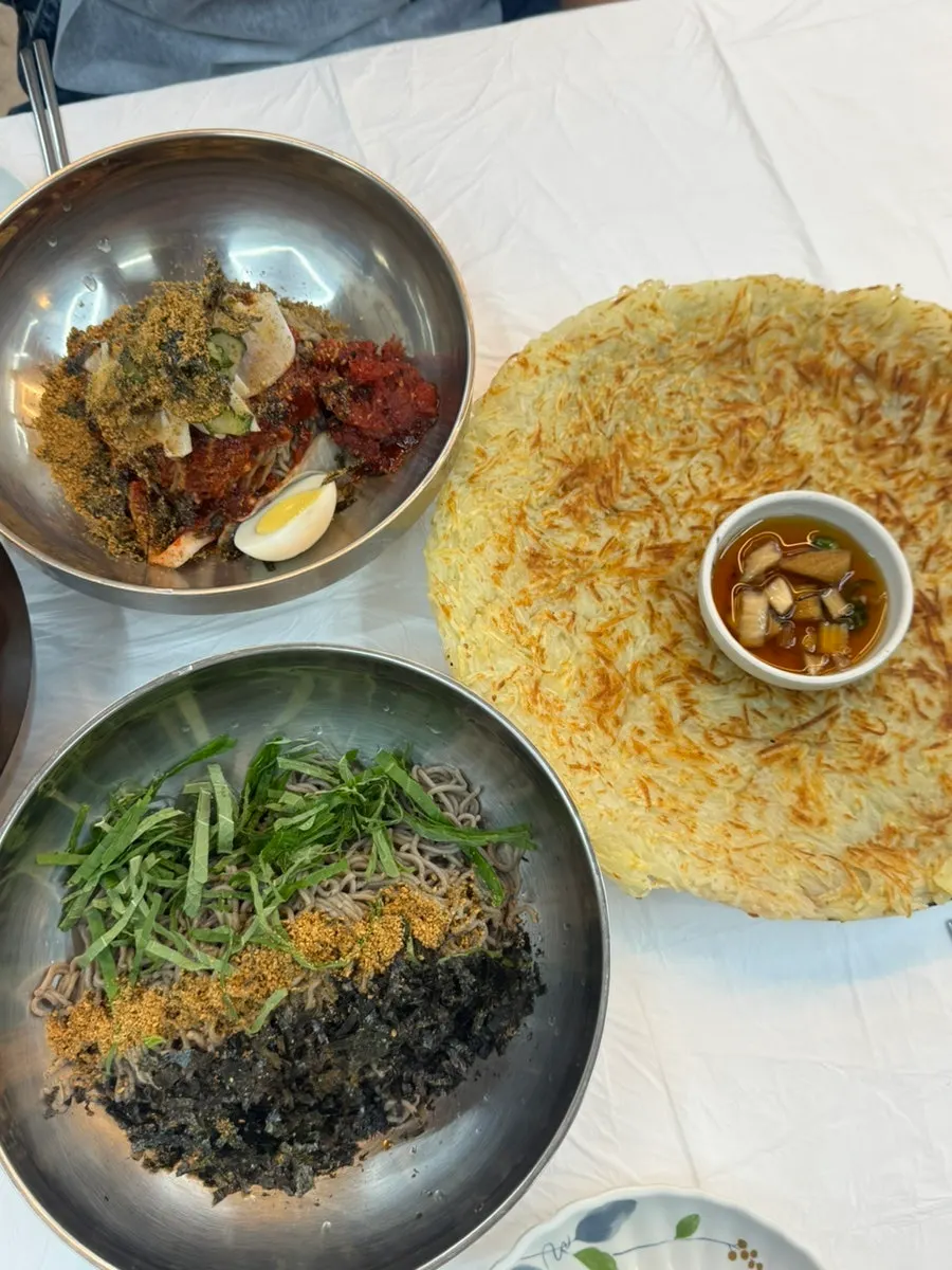 Table set with deulmemak, pollack sashimi noodles, and potato pancake