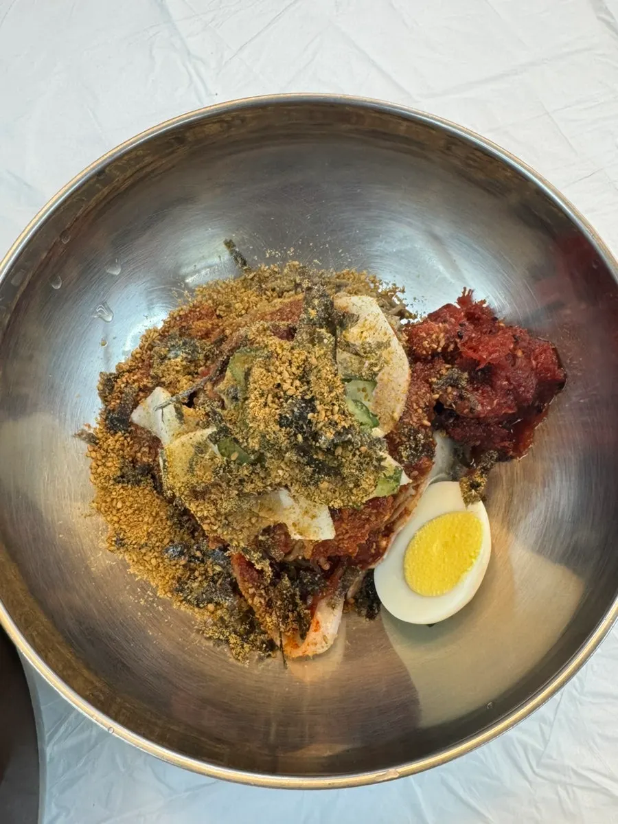 Sokcho pollack sashimi noodles in red sauce with a boiled egg