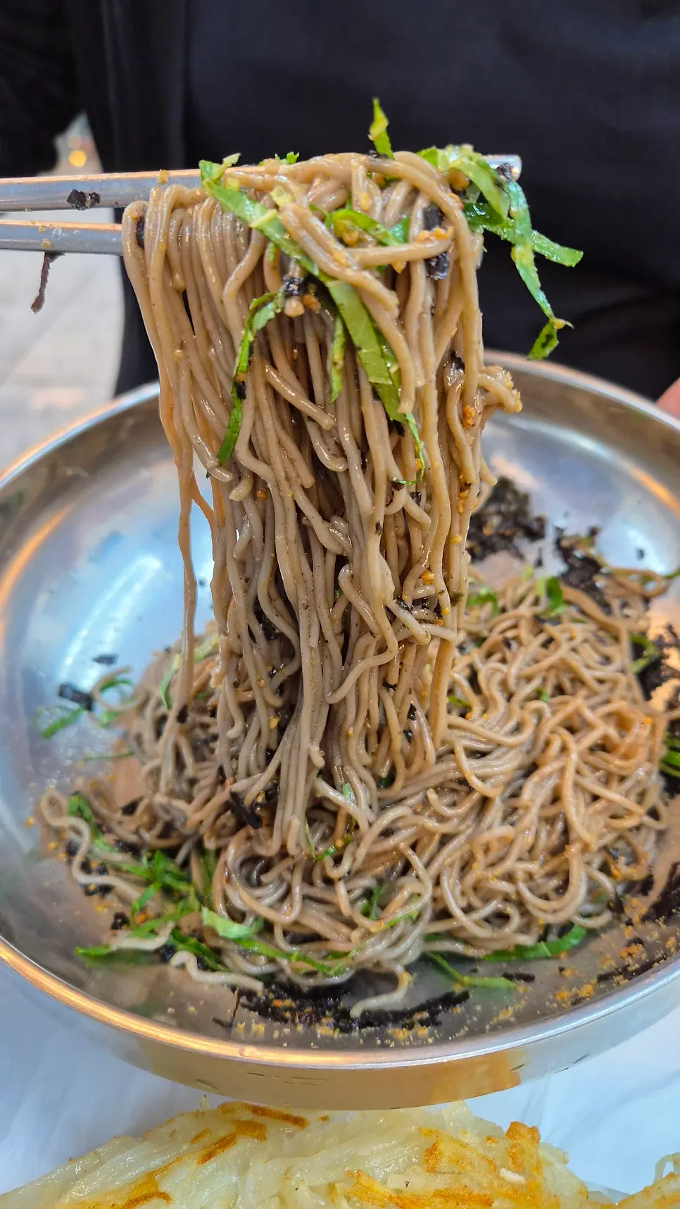 Lifting up the dark, in-house-made buckwheat noodles