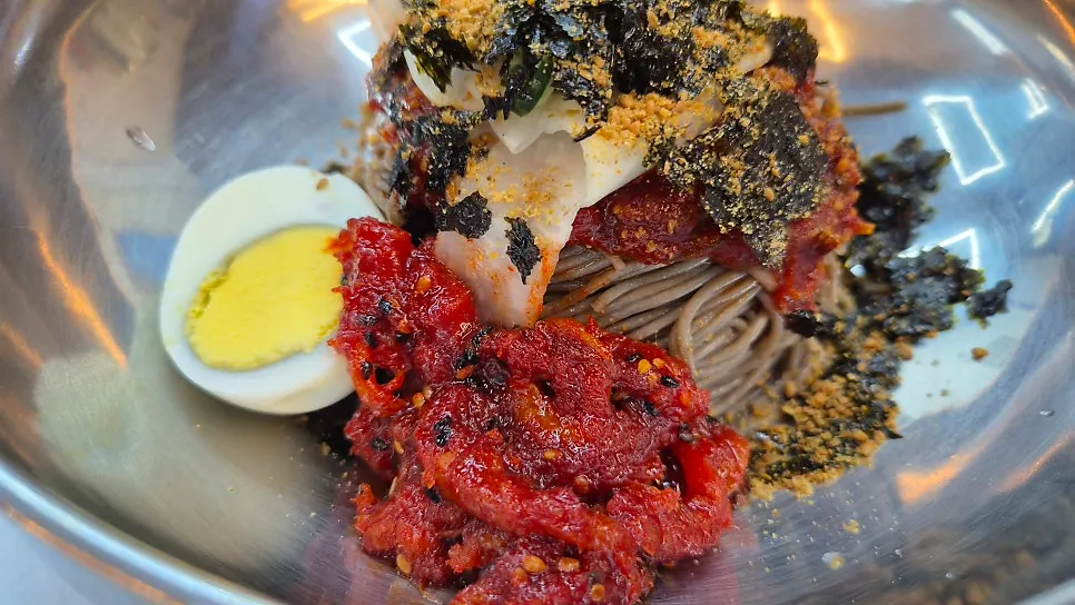A bowl of makguksu transformed with added dongchimi
