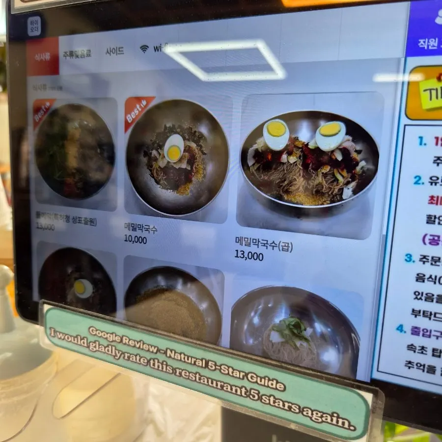 Restaurant sign listing various makguksu menu items