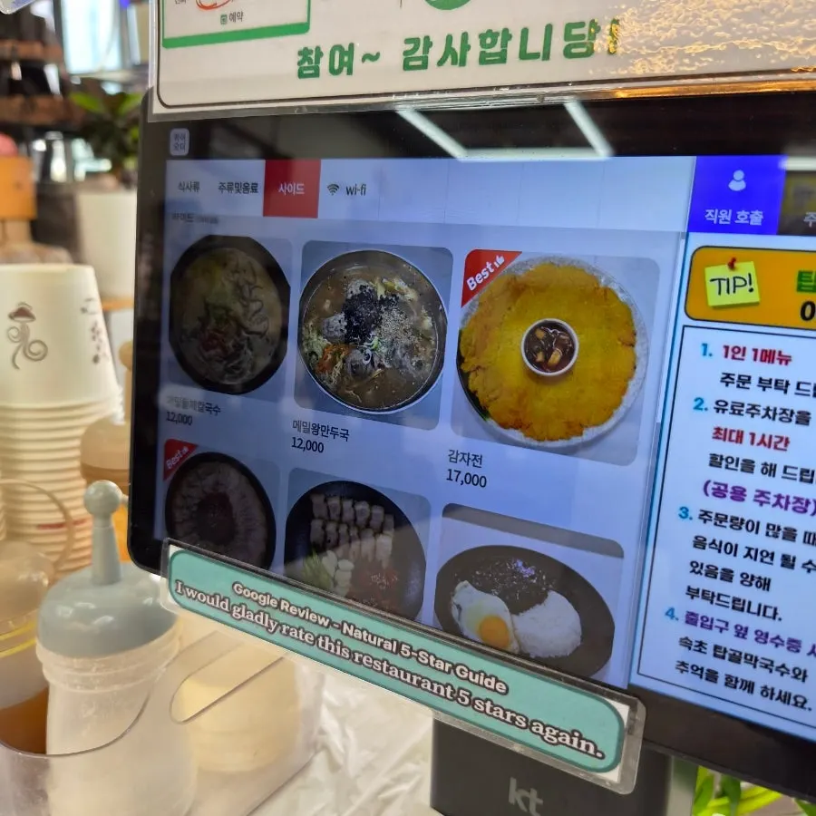 Menu board listing makguksu and side dishes
