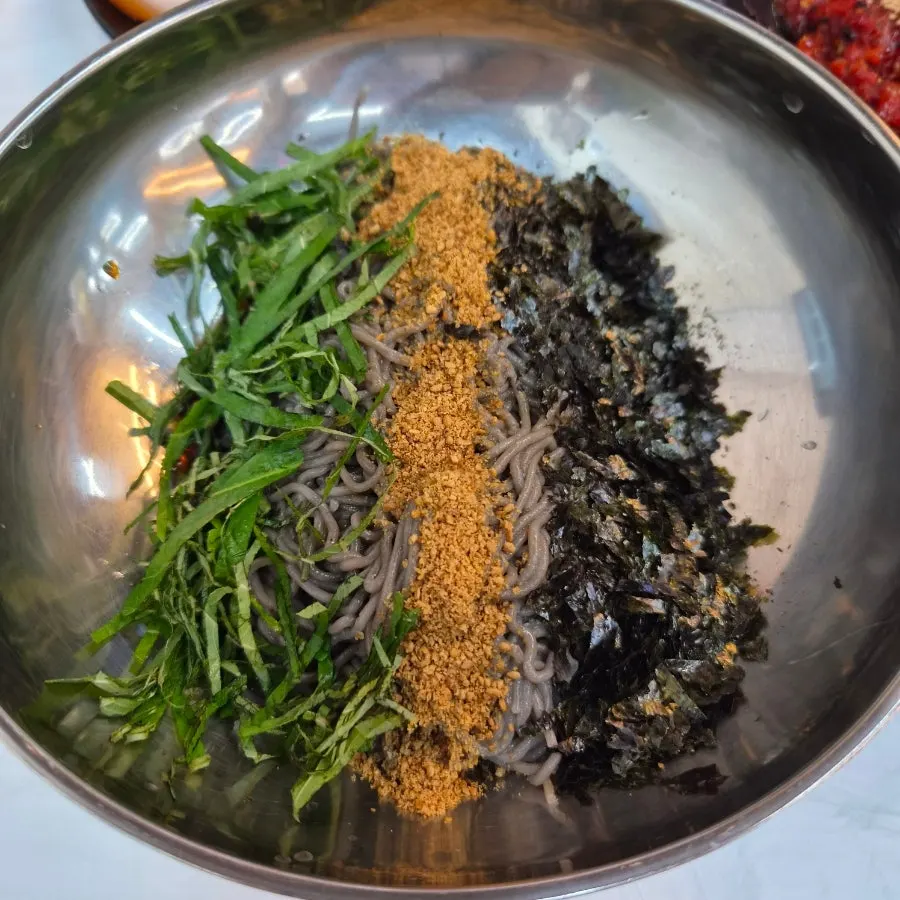 Full table spread with makguksu and side dishes