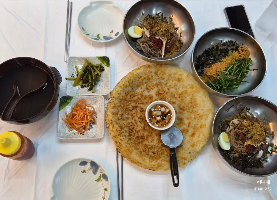 Full table spread of makguksu and potato pancake ordered for 3 people