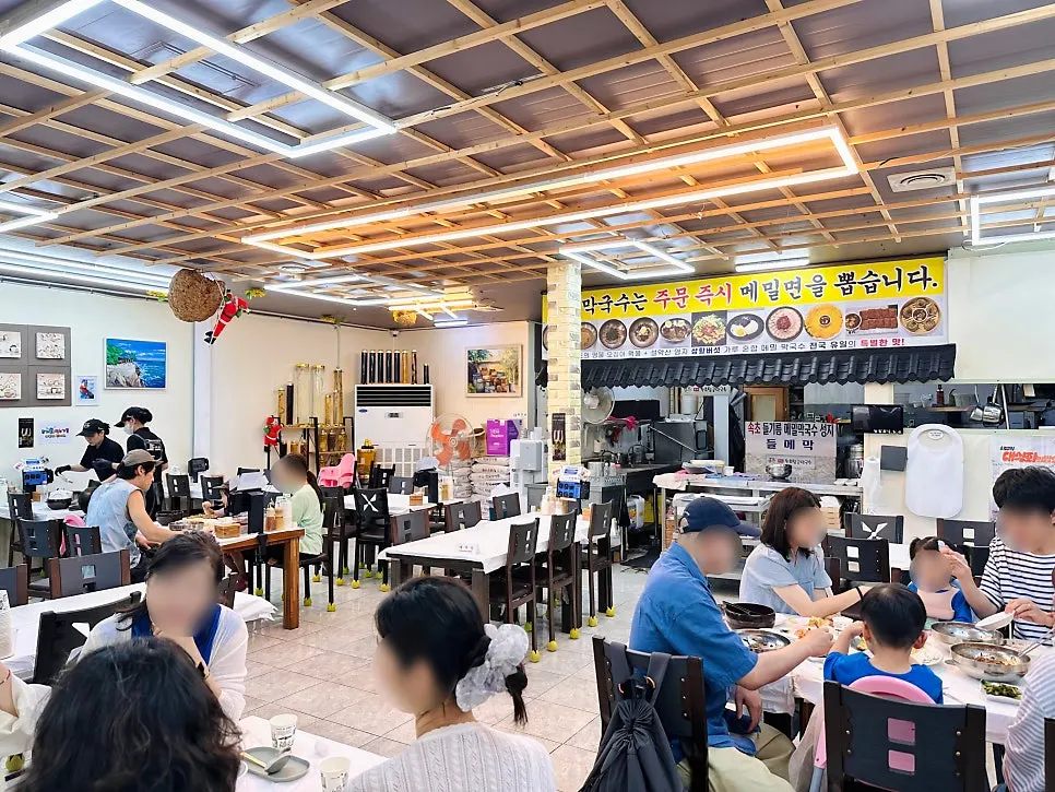 Spacious interior of Sokcho Topgol Makguksu with many tables