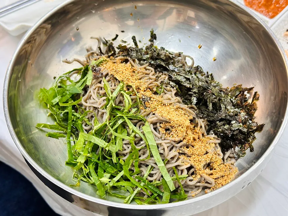 Two bowls of perilla oil buckwheat makguksu and pollack sashimi makguksu