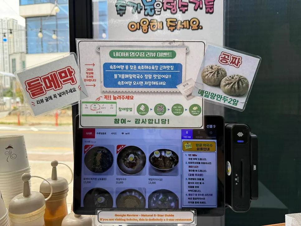 Menu board with makguksu and side dishes at Sokcho Topgol Makguksu