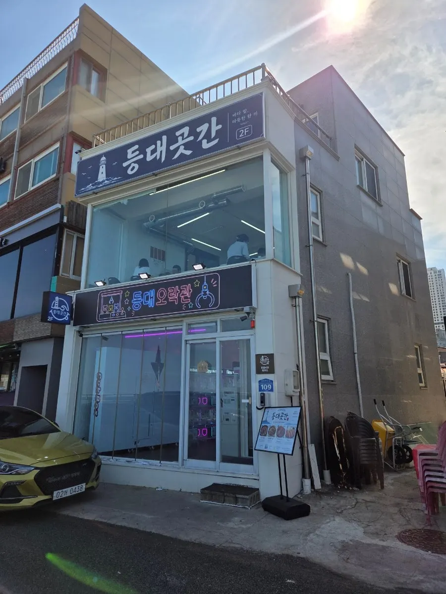 해안가에 위치한 등대곳간 외관과 바다 풍경