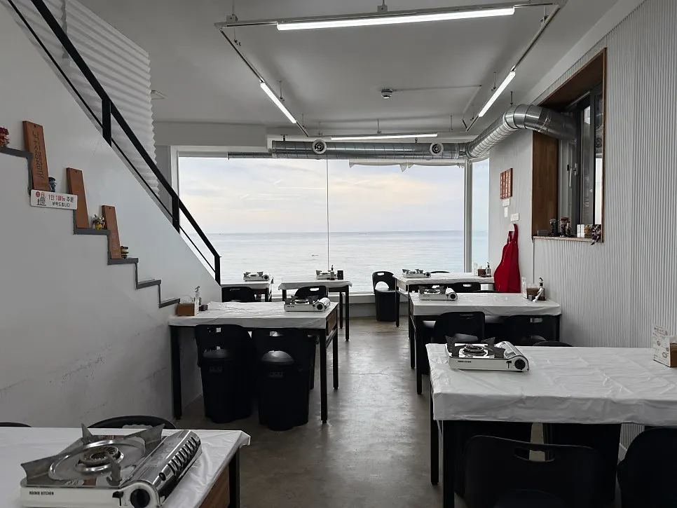 Second-floor dining room with a full window overlooking the Sokcho sea