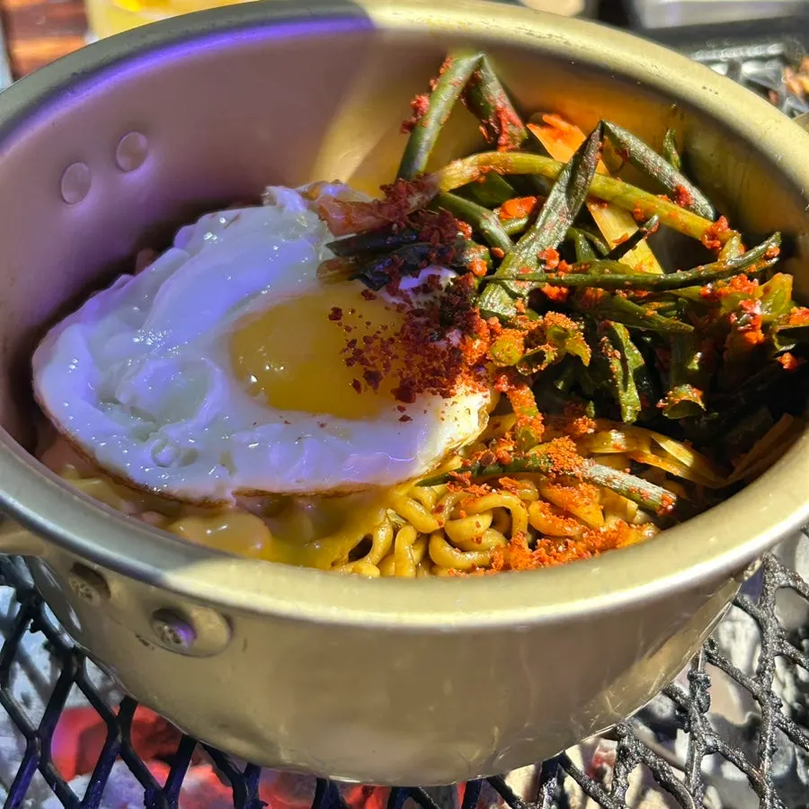 A plate of jjagyechi topped with green onion kimchi